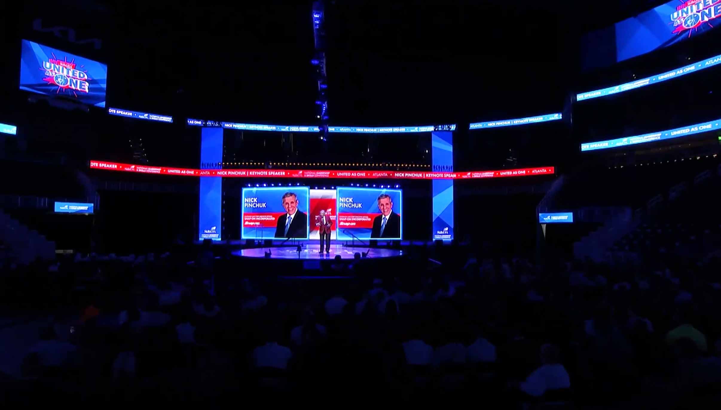 Four officers on stage with photo and name projected in the background.