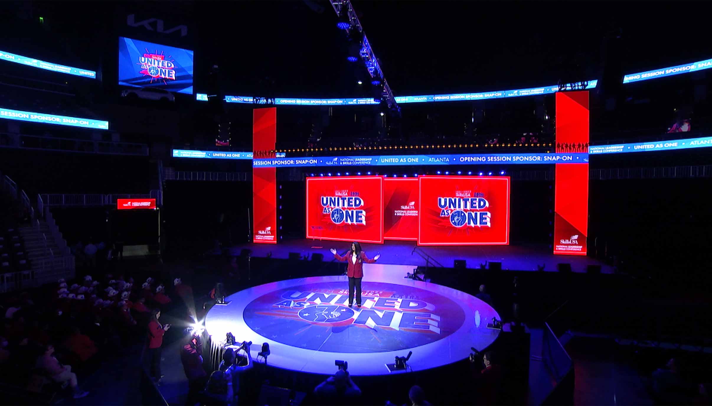 Full auditorium lit in blue with Chapter Advisor of the Year projected onstage.