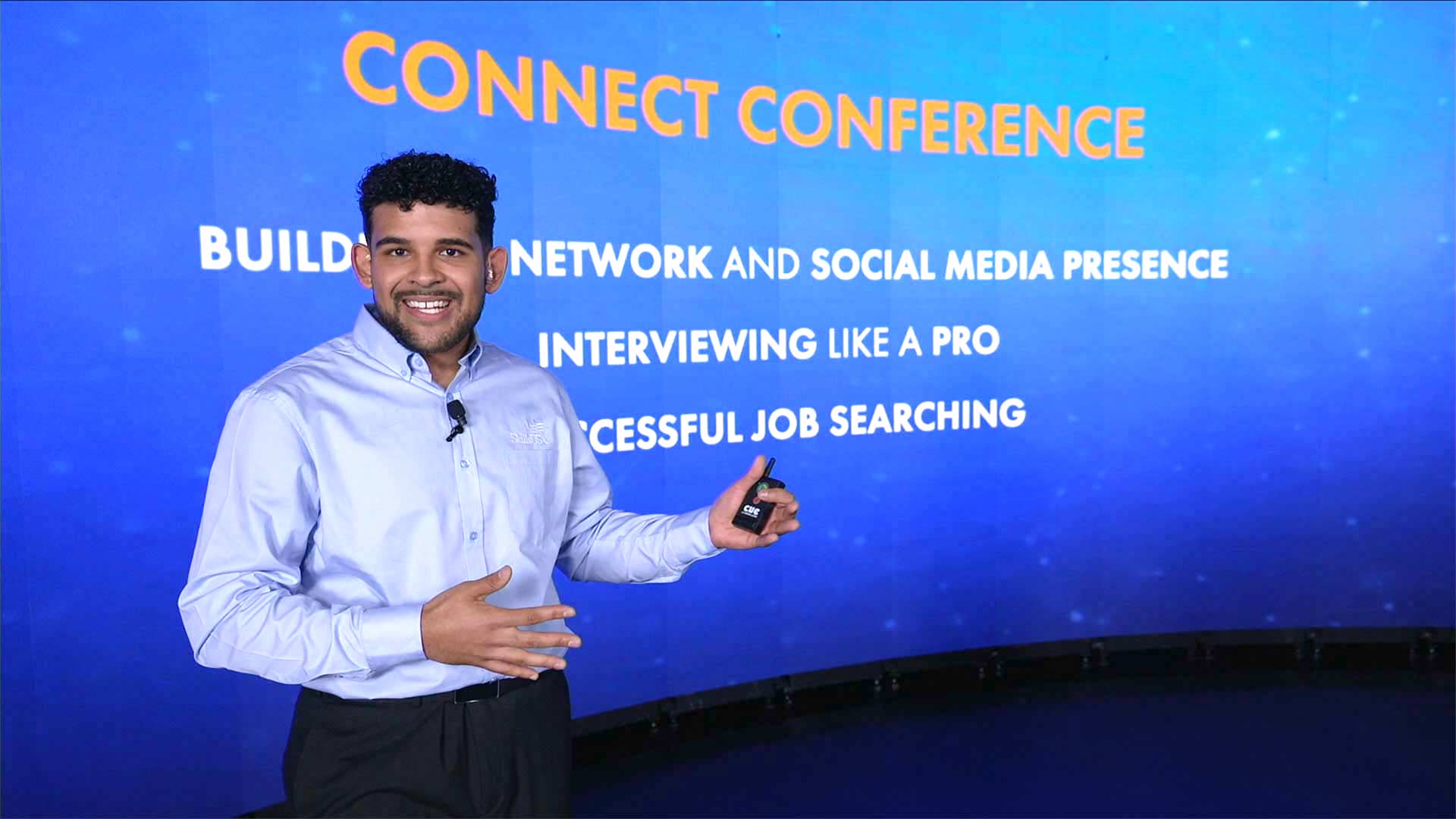 Full auditorium lit in blue with Chapter Advisor of the Year projected onstage.
